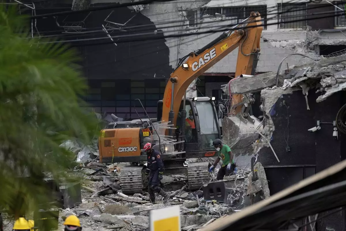 An excavator removes concrete at the Jet Set nightclub after its roof collapsed three nights before during a merengue concert in Santo Domingo, Dominican Republic, Thursday, April 10, 2025. (AP Photo/Matias Delacroix)
