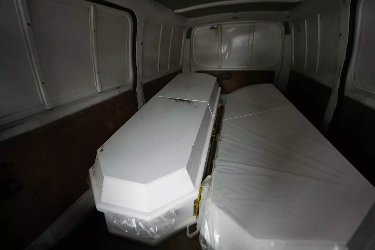 The coffin on the left that contains the remains of a son of Carlos Severino, sits next to an empty coffin that will be used for the remains of another son of Severino, who lost three sons when the Jet Set nightclub roof collapsed, outside the morgue of the National Institute of Forensic Pathology in Santo Domingo, Dominican Republic, Friday, April 11, 2025. (AP Photo/Matias Delacroix)