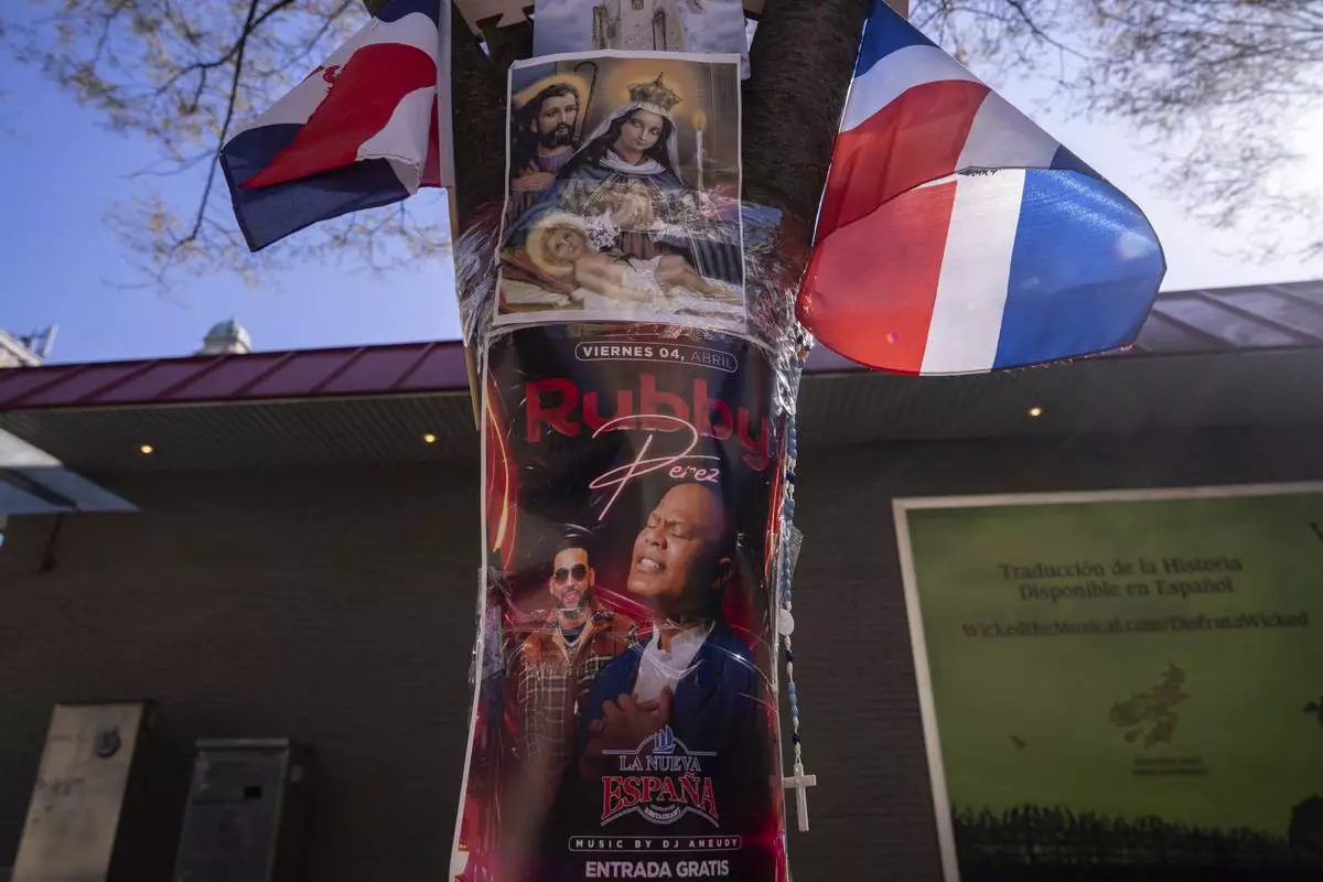 A poster of victim Rubby Perez is seen at a makeshift vigil for the victims of the Jet Set club roof collapse in the Dominican Republic, Wednesday, April 9, 2025, in New York. (AP Photo/Adam Gray)