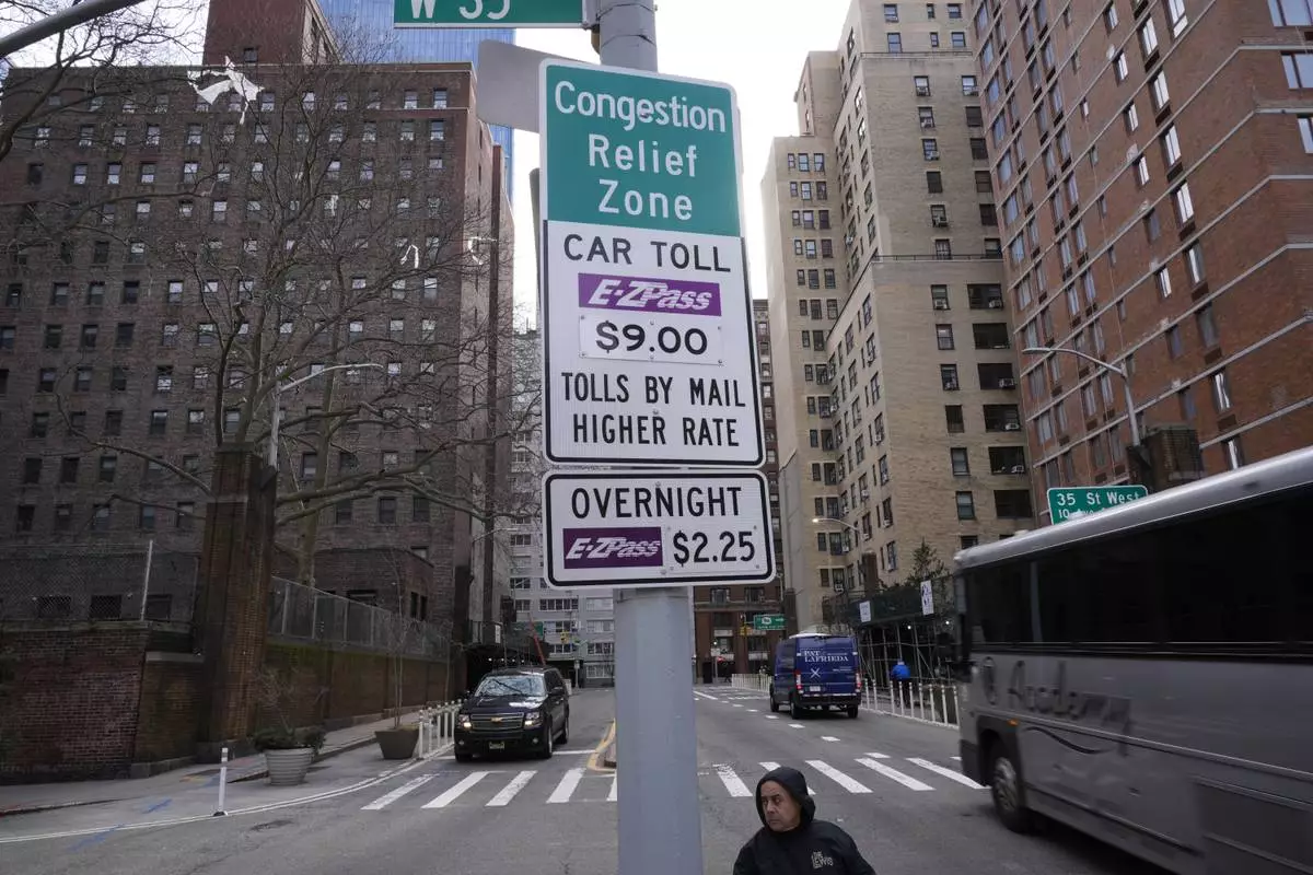 FILE - Signs advising drivers of congestion pricing tolls are displayed near the exit of the Lincoln Tunnel in New York, Wednesday, Feb. 19, 2025. (AP Photo/Seth Wenig, File)