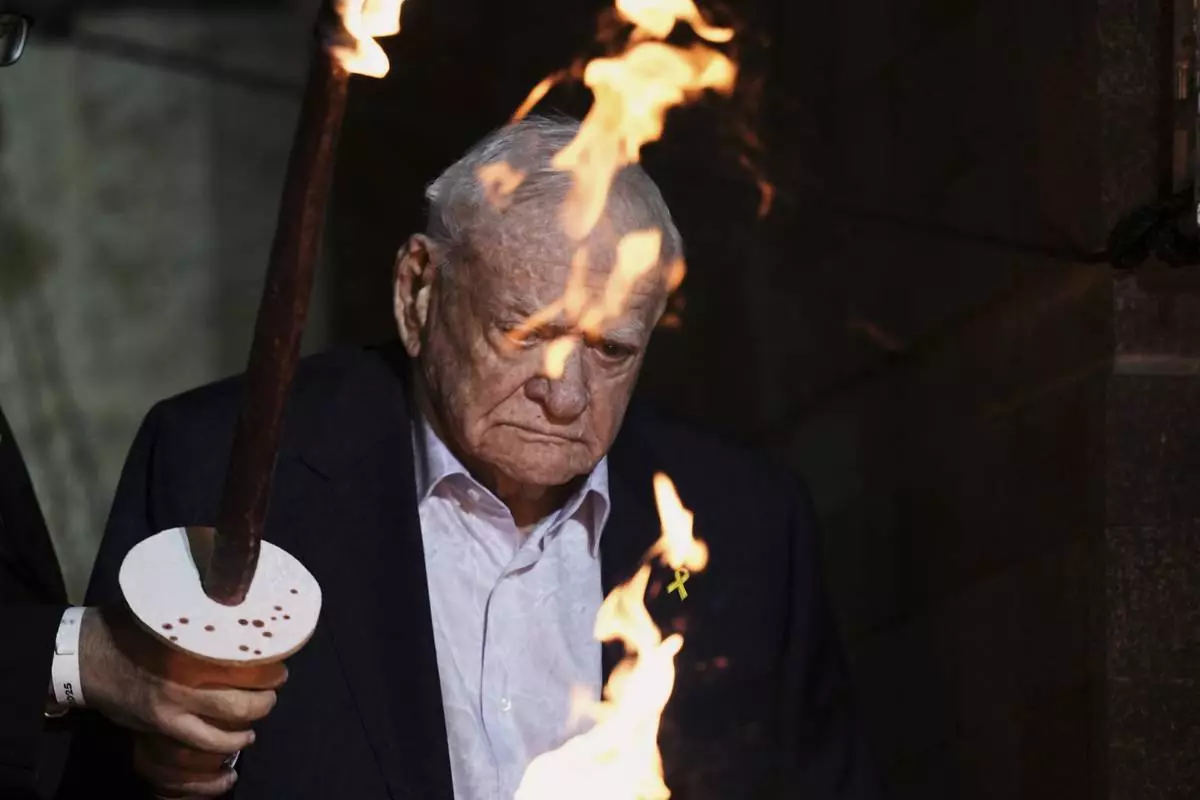 Holocaust survivor Arie Durst lights a torch during the opening ceremony of the Holocaust Remembrance Day at the Yad Vashem Holocaust Memorial Museum in Jerusalem on Wednesday, April 23, 2025. (AP Photo/Leo Correa)