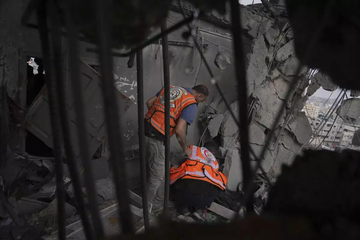 Palestinians civil defense workers search through the debris following an Israeli airstrike on a residential building in Gaza City, Thursday, April 24, 2025. (AP Photo/Jehad Alshrafi)