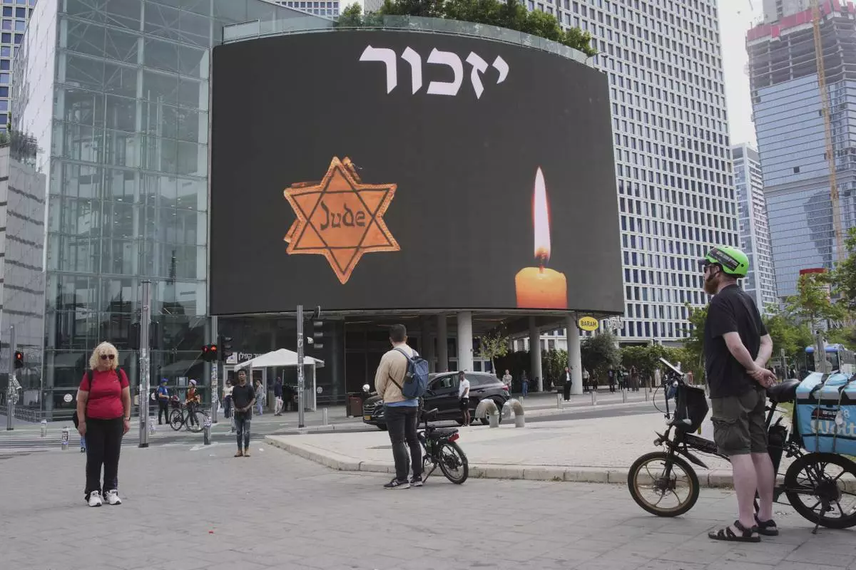 People stand during a two-minute siren marking the annual Israeli Holocaust Remembrance Day in Tel Aviv, Israel, Thursday, April 24, 2025. (AP Photo/Ohad Zwigenberg)