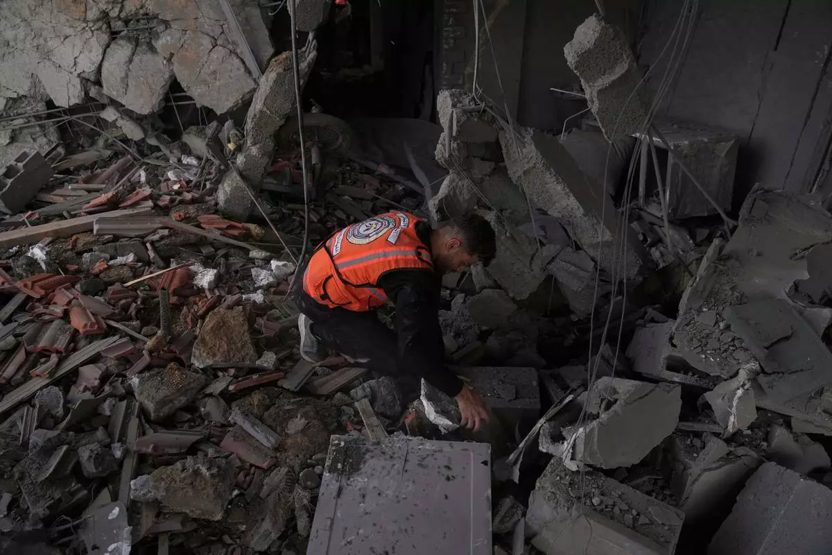 A Palestinian civil defense worker searches through the debris following an Israeli airstrike on a residential building in Gaza City, Thursday, April 24, 2025. (AP Photo/Jehad Alshrafi)