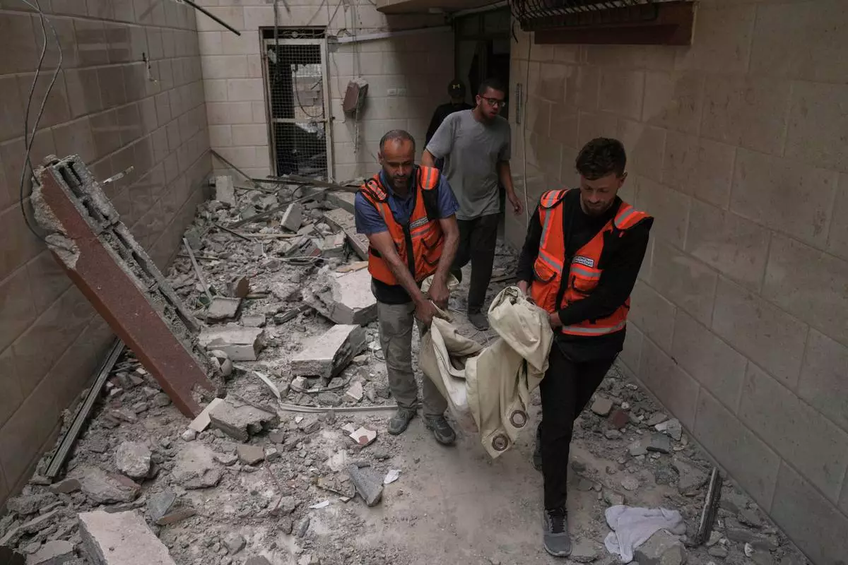 Palestinian civil defense workers carry the remains of a person killed during an Israeli airstrike on a residential building in Gaza City, Thursday, April 24, 2025. (AP Photo/Jehad Alshrafi)