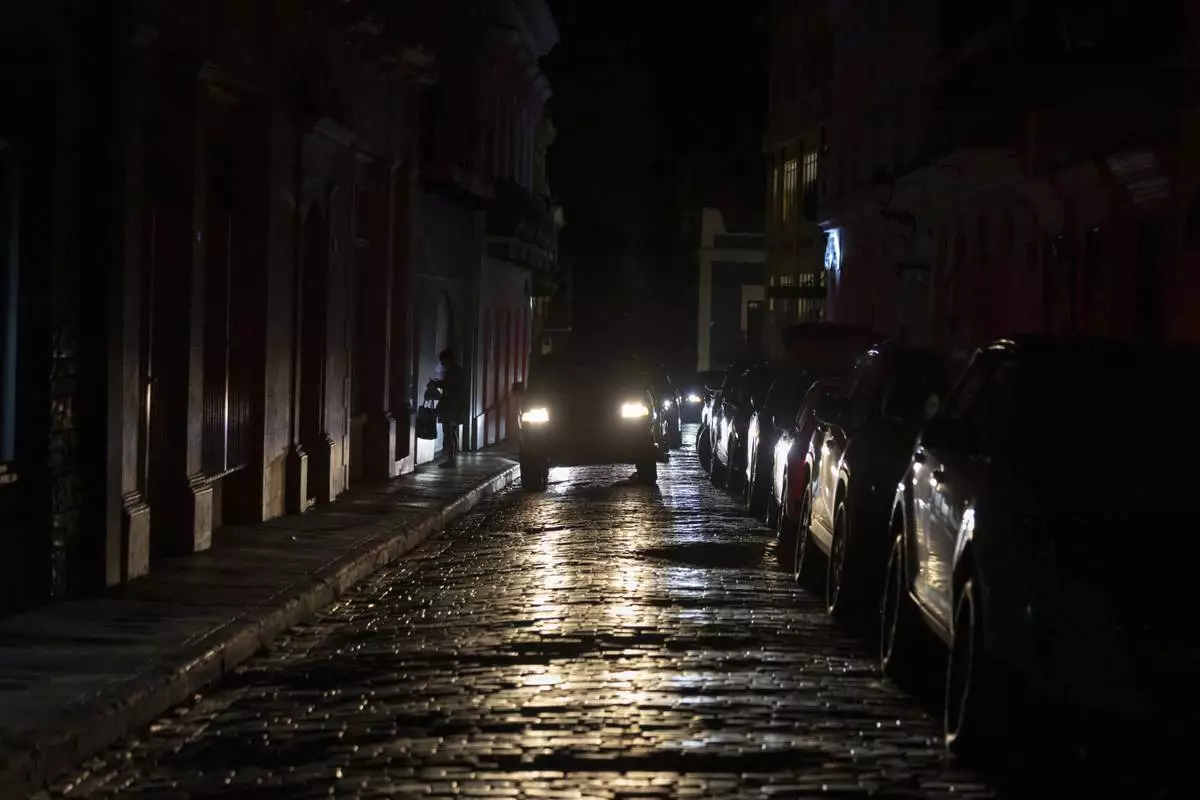 Headlights illuminate cobblestone streets in Old San Juan, Puerto Rico, during an island-wide blackout, Wednesday, April 16, 2025. (AP Photo/Alejandro Granadillo)