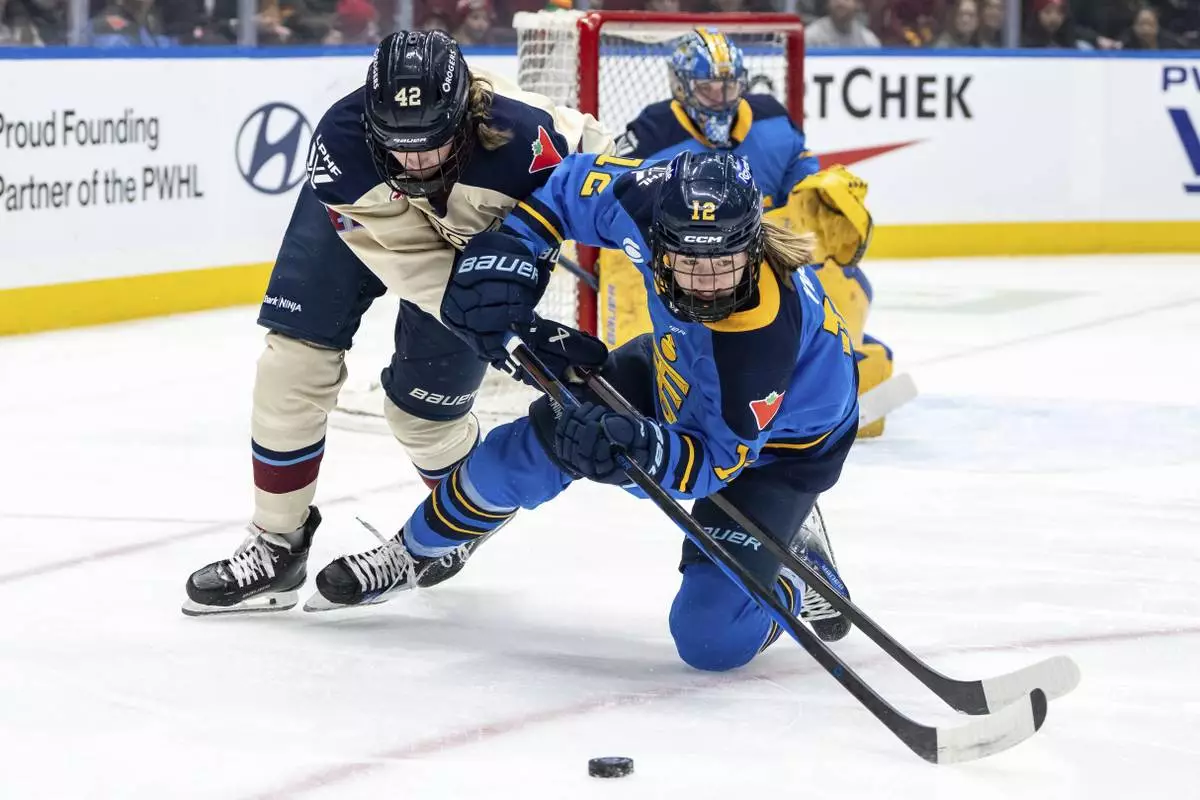 FILE - Montreal Victoire's Claire Dalton (42) and Toronto Sceptres' Allie Munroe (12) vie for the puck during first period PWHL hockey action in Vancouver, on Wednesday, January 8, 2025. (Ethan Cairns/The Canadian Press via AP, File)