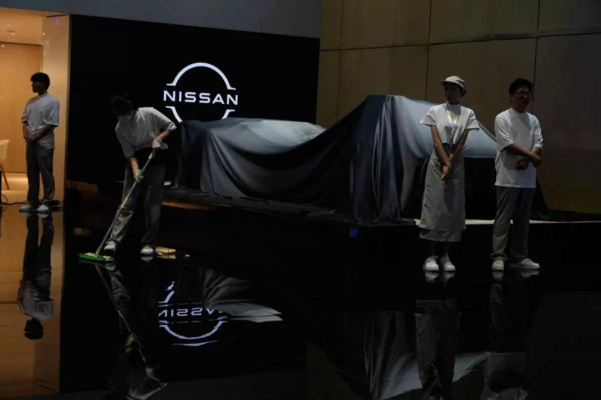 Exhibitors prepare for an unveiling at the Auto Show in Shanghai, Wednesday, April 23, 2025. (AP Photo/Ng Han Guan)