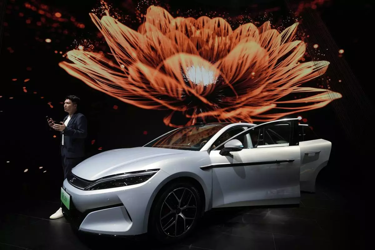 A man talks near the Han L EV model from BYD during the Shanghai auto show on Wednesday, April 23, 2025. (AP Photo/Ng Han Guan)