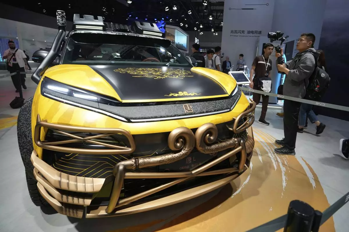 A man films near a special Black Myth:Wukong edition of a Tang L model from BYD during the Shanghai auto show on Wednesday, April 23, 2025. (AP Photo/Ng Han Guan)
