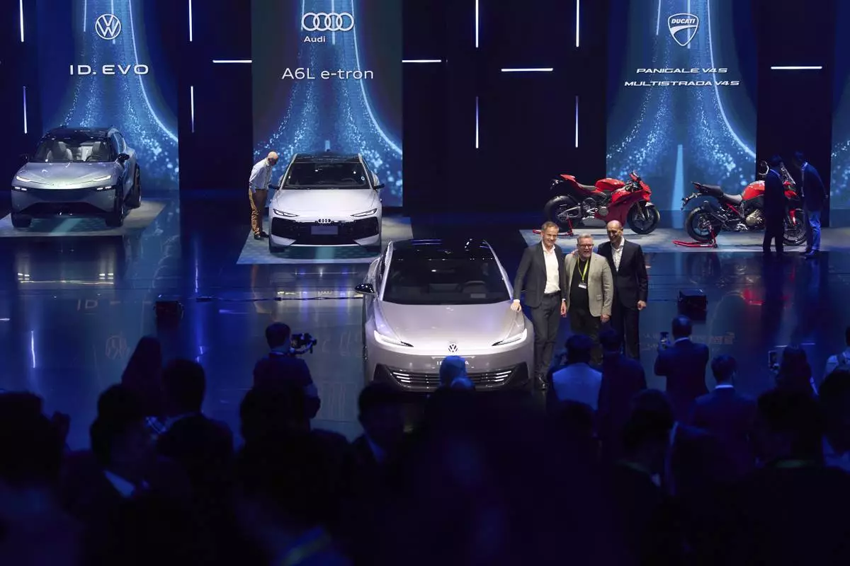 Volkswagen executives and guest pose for photos during the Volkswagen Group media night ahead of the Auto Show in Shanghai, Tuesday, April 22, 2025. (AP Photo/Ng Han Guan)