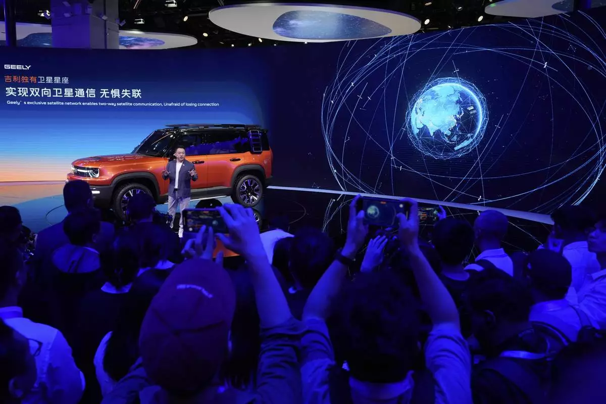 An executive from Chinese car manufacturer Geely talks the satellite communication capabilities of its Galaxy Cruiser during the Shanghai auto show on Wednesday, April 23, 2025. (AP Photo/Ng Han Guan)