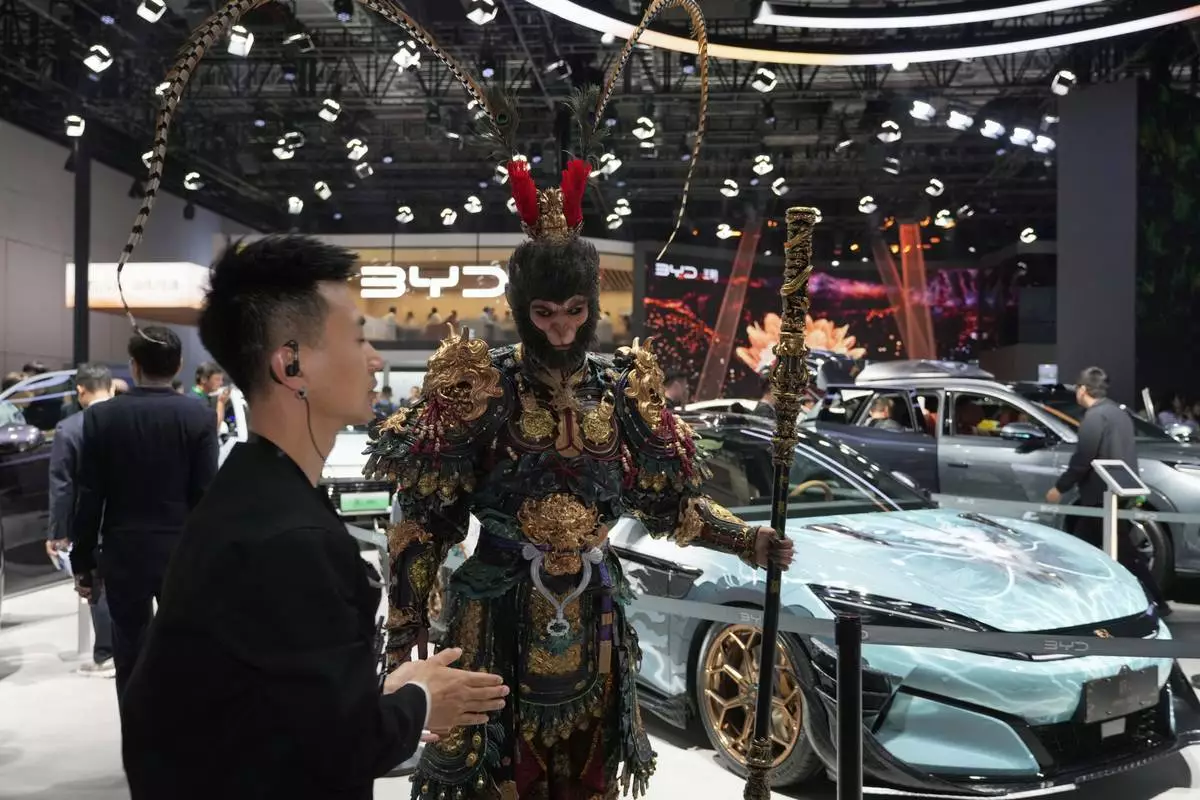 A man dressed as the character from Black Myth:Wukong promotes a special edition Han L model from BYD during the Shanghai auto show on Wednesday, April 23, 2025. (AP Photo/Ng Han Guan)