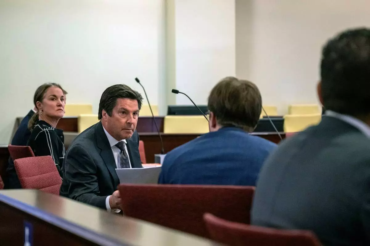 Kurt Sommer, representing the personal representative of the Hackman estate, Julia Peters, hands documents over to Walker Boyd, attorney for Santa Fe County in court before Judge Matthew J. Wilson in District Court in Santa Fe, N.M., Monday, March 31, 2025. (Michael G. Seamans/Santa Fe New Mexican via AP)