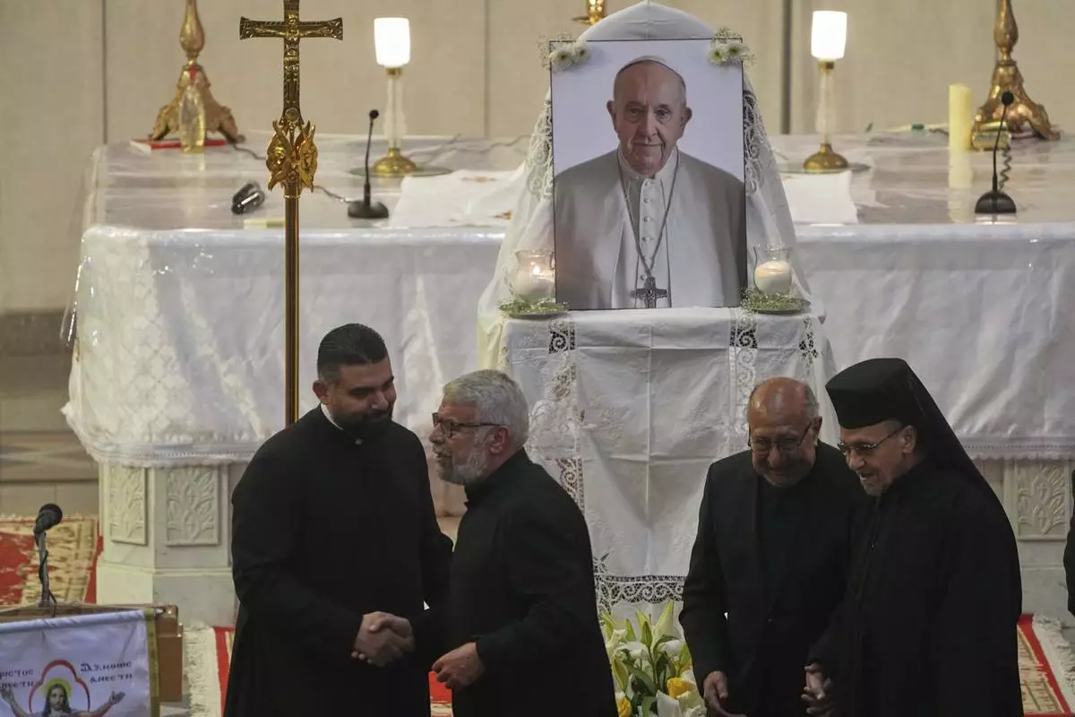 Egyptian Coptic Catholic priests share condolences after a service for late Pope Francis at the Holy Virgin Mary Coptic Catholic Cathedral in Cairo, Egypt, Tuesday, April 22, 2025. (AP Photo/Amr Nabil)