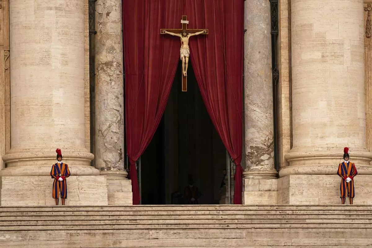 Pontifical Swiss guards stand outside the St. Peter's Basilica, in St. Peter's Square, where the body of Pope Francis will lie in state at for three days, at the Vatican, Wednesday, April 23, 2025. (AP Photo/Andreea Alexandru)