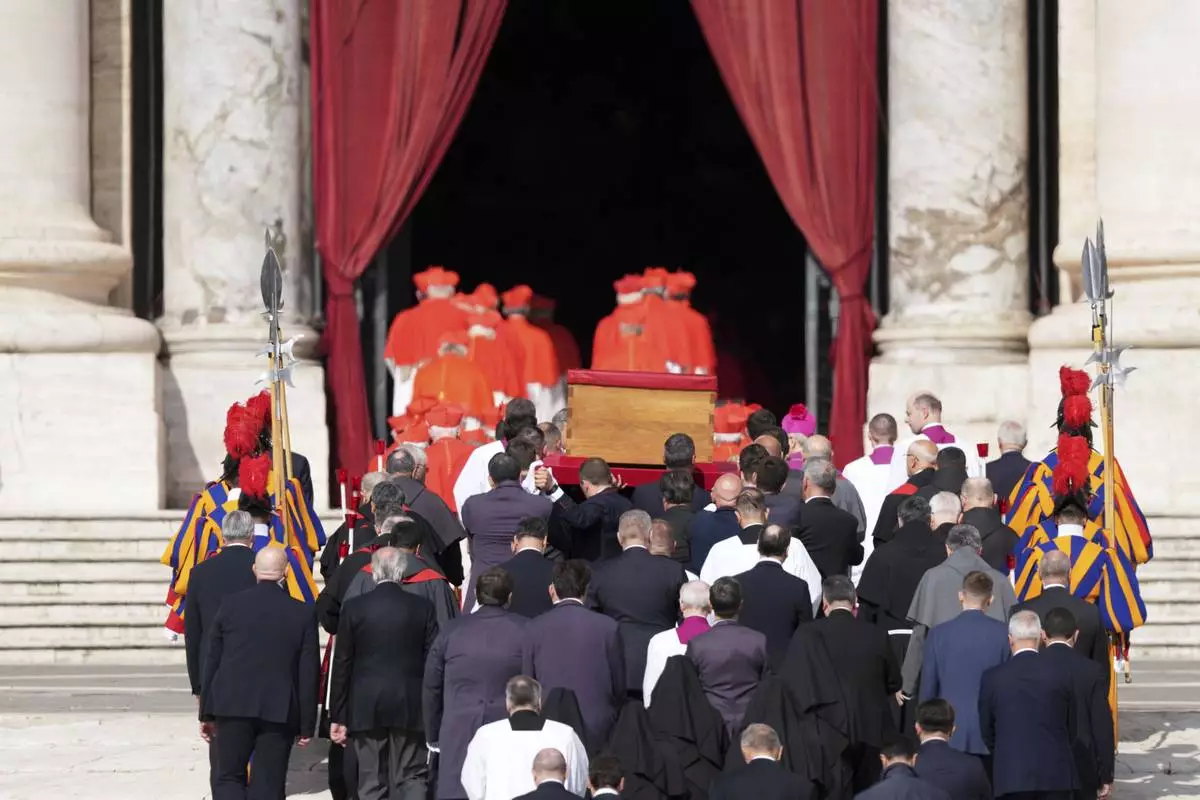 The body of Pope Francis is carried through St. Peter's Square to St. Peter's Basilica at the Vatican, Wednesday, April 23, 2025, where he will lie in state for three days. (AP Photo/Stefano Costantino)