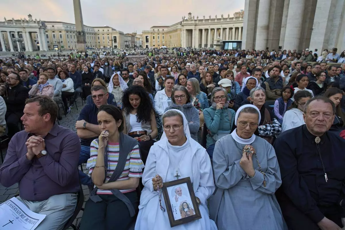 Faithful attend a rosary prayer for the late Pope Francis, in St. Peter's Square at the Vatican, Tuesday April 22, 2025. (AP Photo/Bernat Armangue)