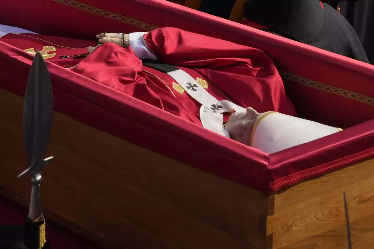 The ceremony with the Pope Francis' body, who will lie in state at St. Peter's Basilica for three days, pass through the crowd at the Vatican, Wednesday, April 23, 2025. (AP Photo/Gregorio Borgia)