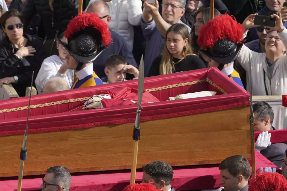 The body of Pope Francis is carried through St. Peter's Square to St. Peter's Basilica at the Vatican, Wednesday, April 23, 2025, where he will lie in state for three days. (AP Photo/Markus Schreiber)