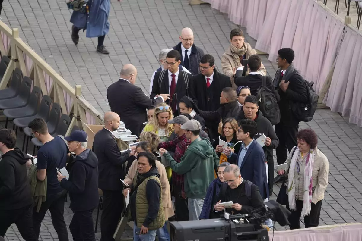 People enter St. Peter's Square ahead of the arrival of the body of Pope Francis, who will lie in state at St. Peter's Basilica for three days, at the Vatican, Wednesday, April 23, 2025. (AP Photo/Gregorio Borgia)