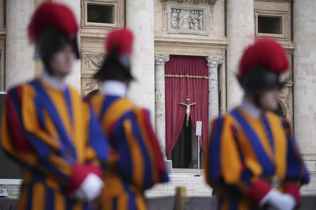 Vatican Swiss Guards frame the entrance of St. Peter's Basilica where the body of Pope Francis will lie in state for three days, at the Vatican, Wednesday, April 23, 2025. (AP Photo/Andrew Medichini)