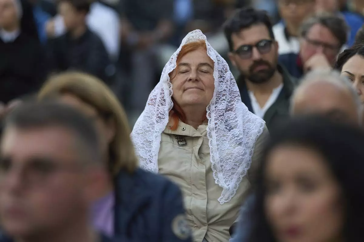 Faithful attend a rosary prayer for the late Pope Francis, in St. Peter's Square at the Vatican, Tuesday April 22, 2025. (AP Photo/Bernat Armangue)