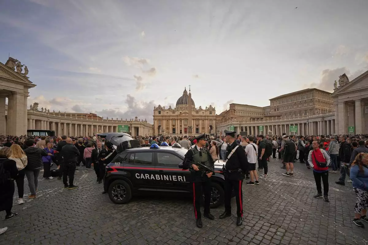 People wait in St. Peter's Square to pay their respects to the late Pope Francis, who will lie in state at St. Peter's Basilica for three days, at the Vatican, Wednesday, April 23, 2025. (AP Photo/Andreea Alexandru)