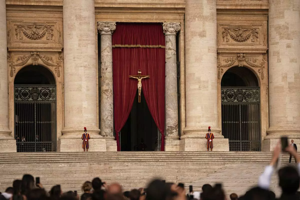People gather in St. Peter's Square as they await the arrival of the body of Pope Francis, who will lie in state at St. Peter's Basilica for three days, at the Vatican, Wednesday, April 23, 2025. (AP Photo/Andreea Alexandru)