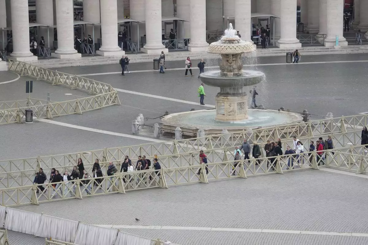 People enter St. Peter's Square ahead of the arrival of the body of Pope Francis, who will lie in state at St. Peter's Basilica for three days, at the Vatican, Wednesday, April 23, 2025. (AP Photo/Gregorio Borgia)