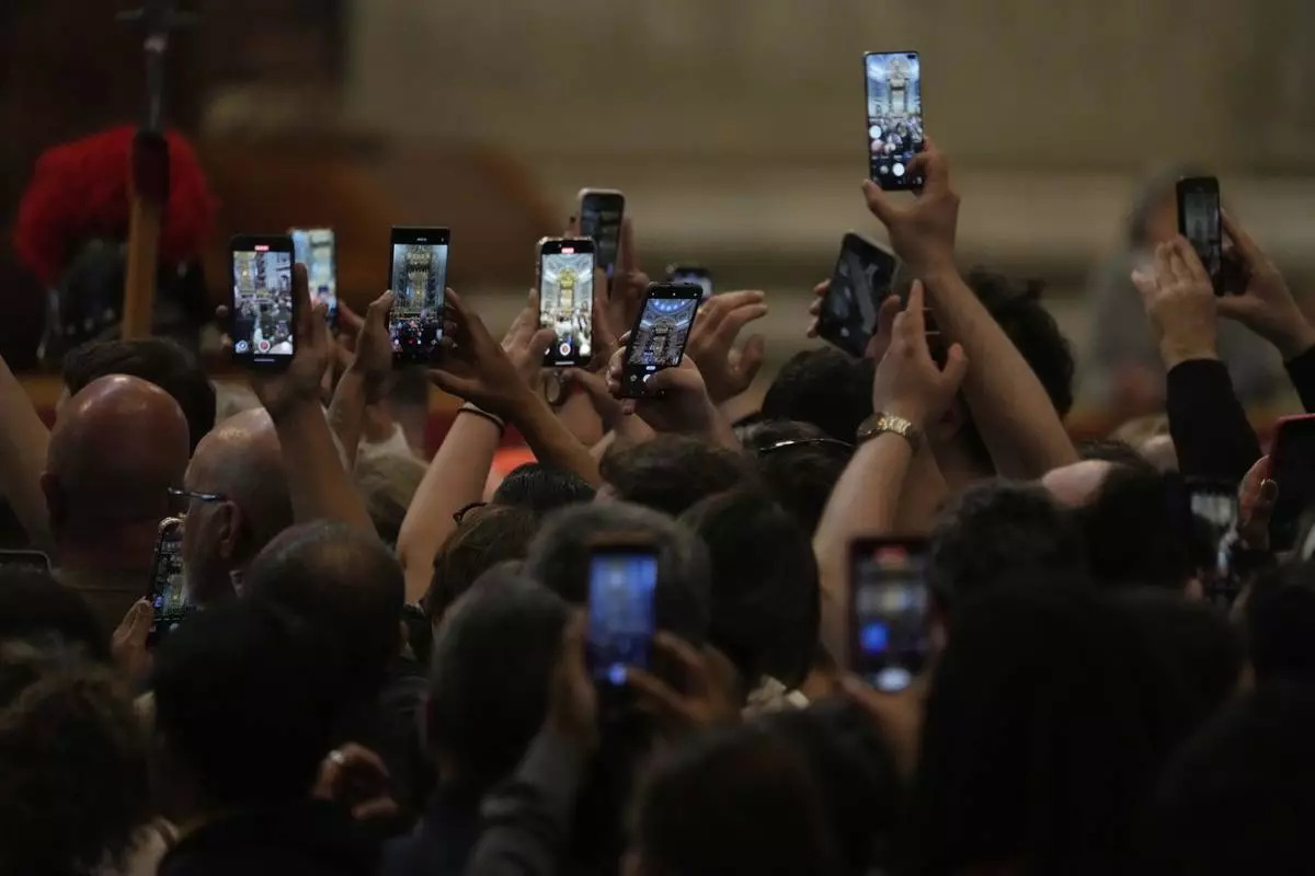 Faithful take photos as they pay their respects to Pope Francis inside St. Peter's Basilica at the Vatican, Wednesday, April 23, 2025, where his body will lie in state for three days. (AP Photo/Gregorio Borgia)