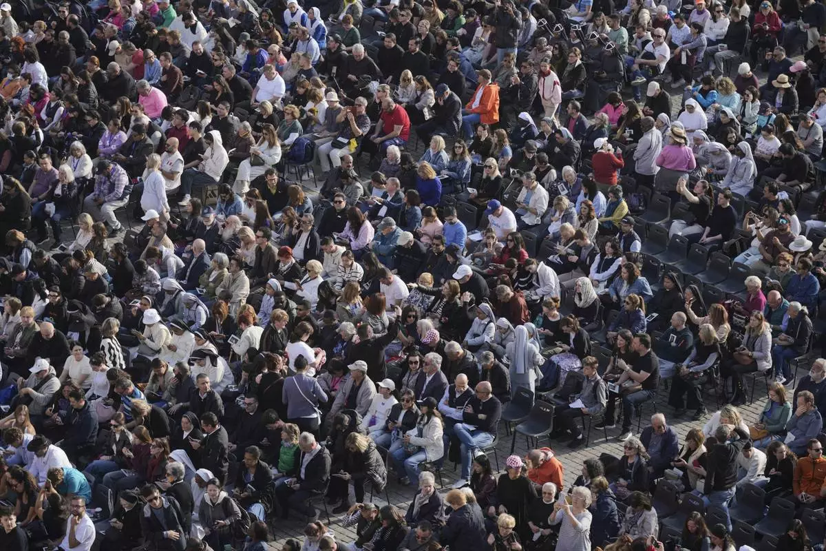 People gather in St. Peter's Square as they await the arrival of the body of Pope Francis, who will lie in state at St. Peter¥s Basilica for three days, at the Vatican, Wednesday, April 23, 2025. (AP Photo/Markus Schreiber)