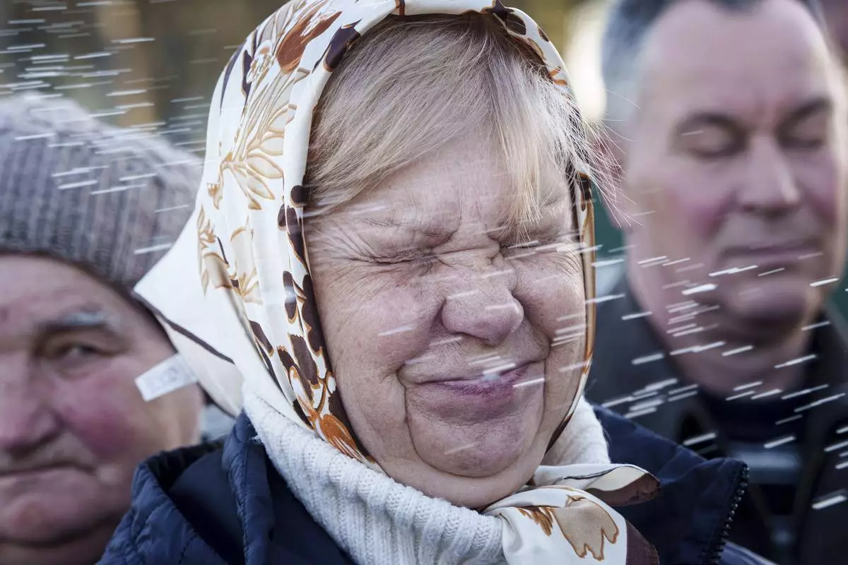 A women is blessed by a priest during celebration of the Orthodox Easter in Krasne village, Ukraine, on Sunday, April 20, 2025. (AP Photo/Evgeniy Maloletka)