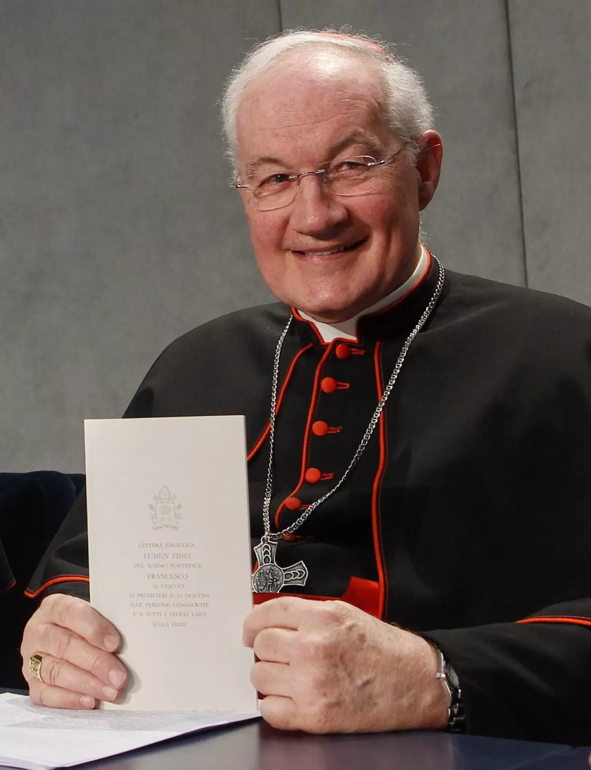 FILE - Cardinal Marc Ouellet shows a copy of the Pope Francis' Lumen Fidei encyclical letter prior to the start of a press conference for its presentation at the Vatican, Wednesday, July 3, 2013. (AP Photo/Riccardo De Luca, file)