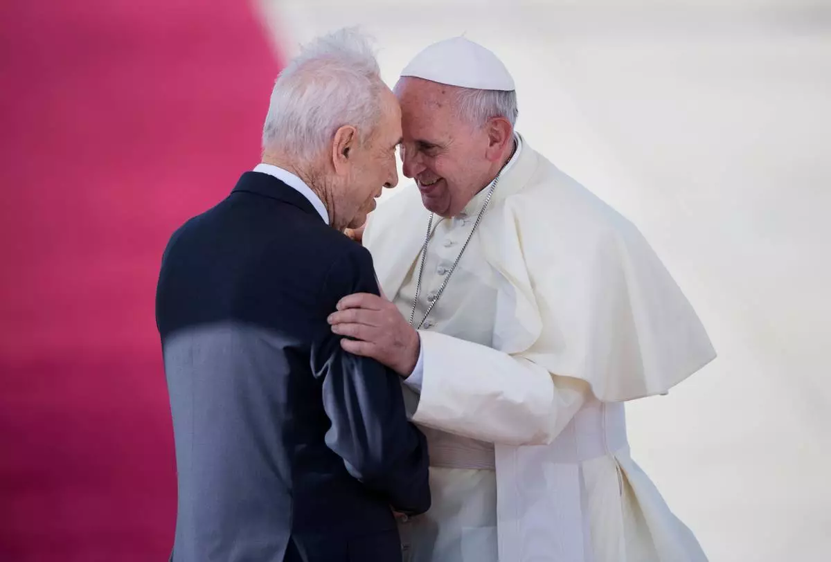 FILE - Pope Francis, right, talks with Israeli President Shimon Peres, during an official arrival ceremony at Ben Gurion airport near Tel Aviv, Israel, Sunday, May 25, 2014. (AP Photo/Oded Balilty, File)