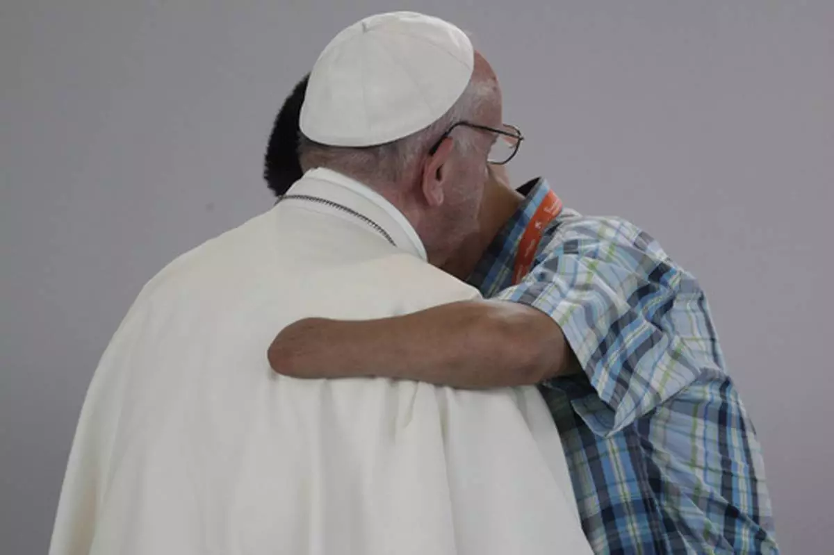 FILE - Former FARC rebel Carlos Juan Carlos Murcia, who lost his left hand, embraces Pope Francis during a prayer meeting for reconciliation at Las Malocas Park in Villavicencio, Colombia, Friday, Sept. 8, 2017. (AP Photo/Andrew Medichini, file)