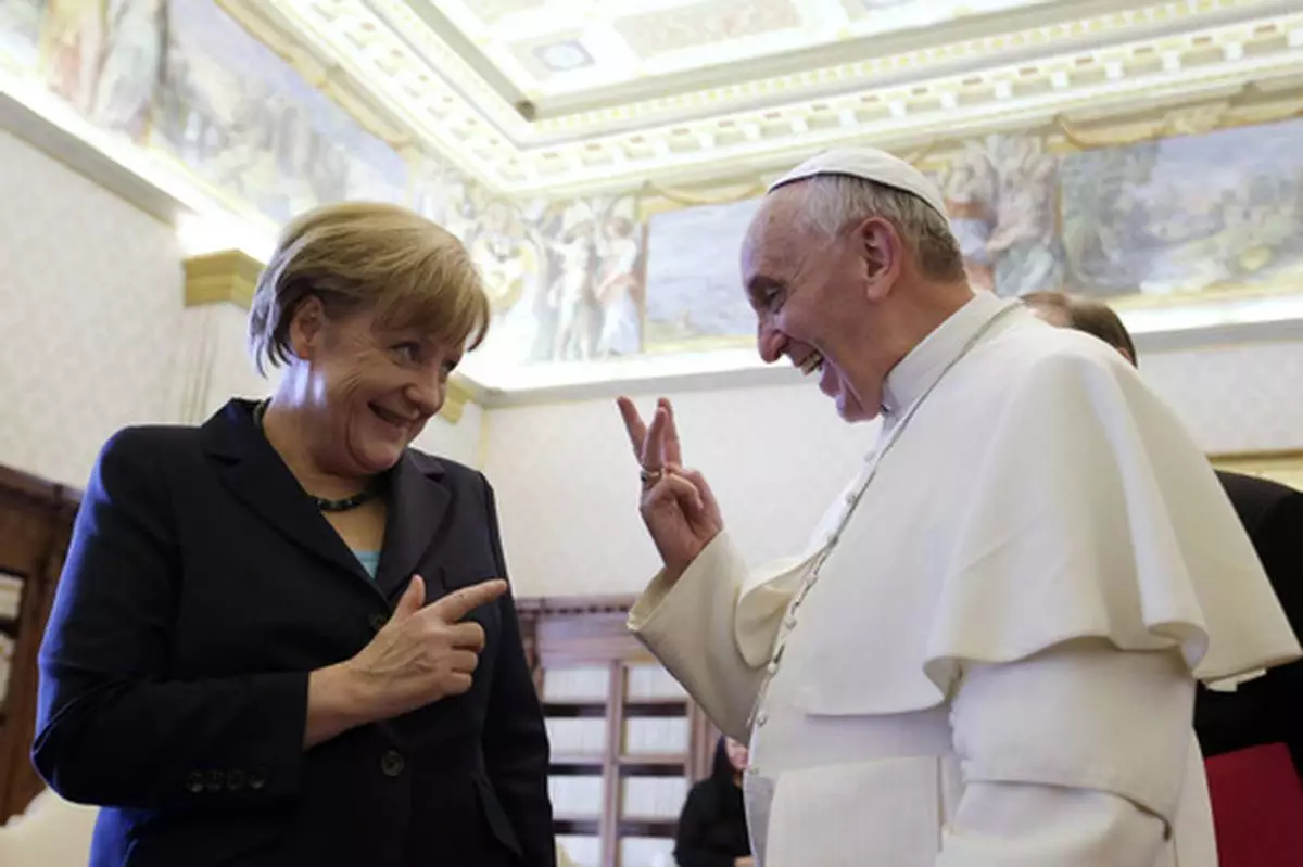 FILE - Pope Francis shares a light moment with German Chancellor Angela Merkel during their private audience at the Vatican, Saturday, May 18, 2013. (AP Photo/Gregorio Borgia, Pool, file)