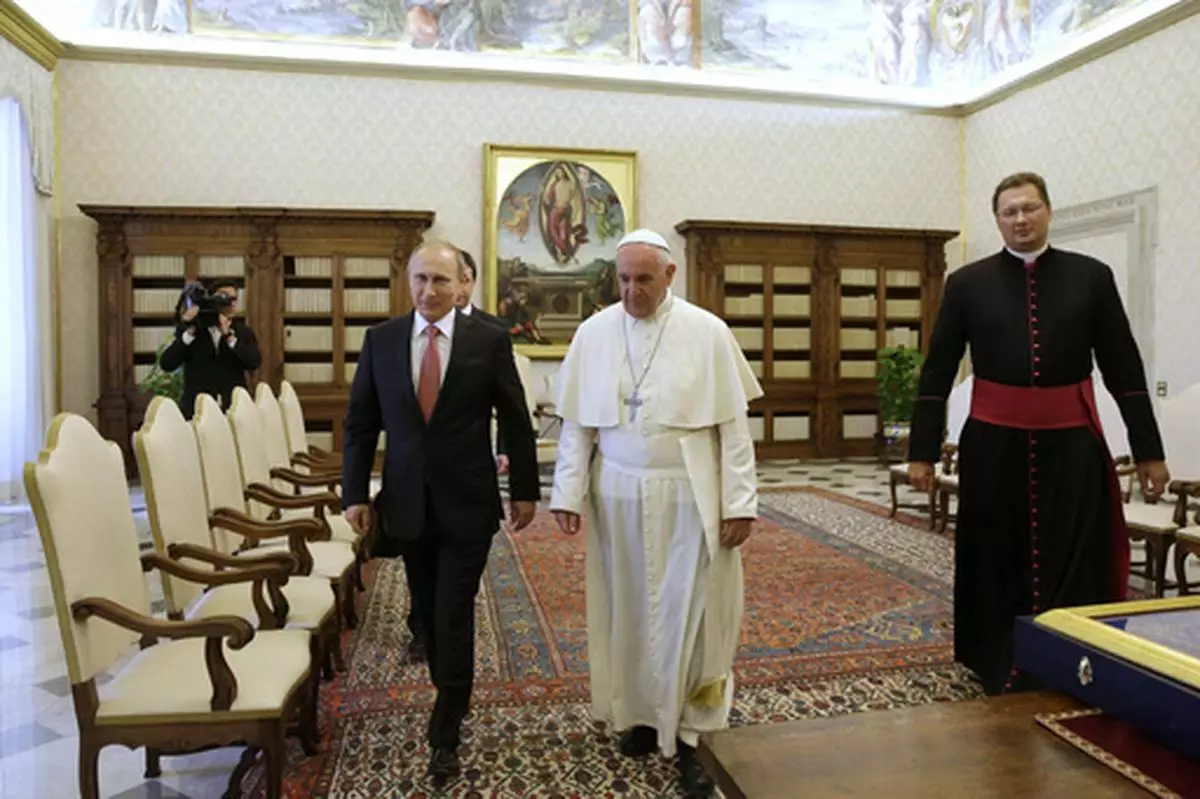 FILE - Pope Francis walks next to Russian President Vladimir Putin on the occasion of their private audience at the Vatican, Wednesday, June 10, 2015. (AP Photo/Gregorio Borgia, Pool, file)