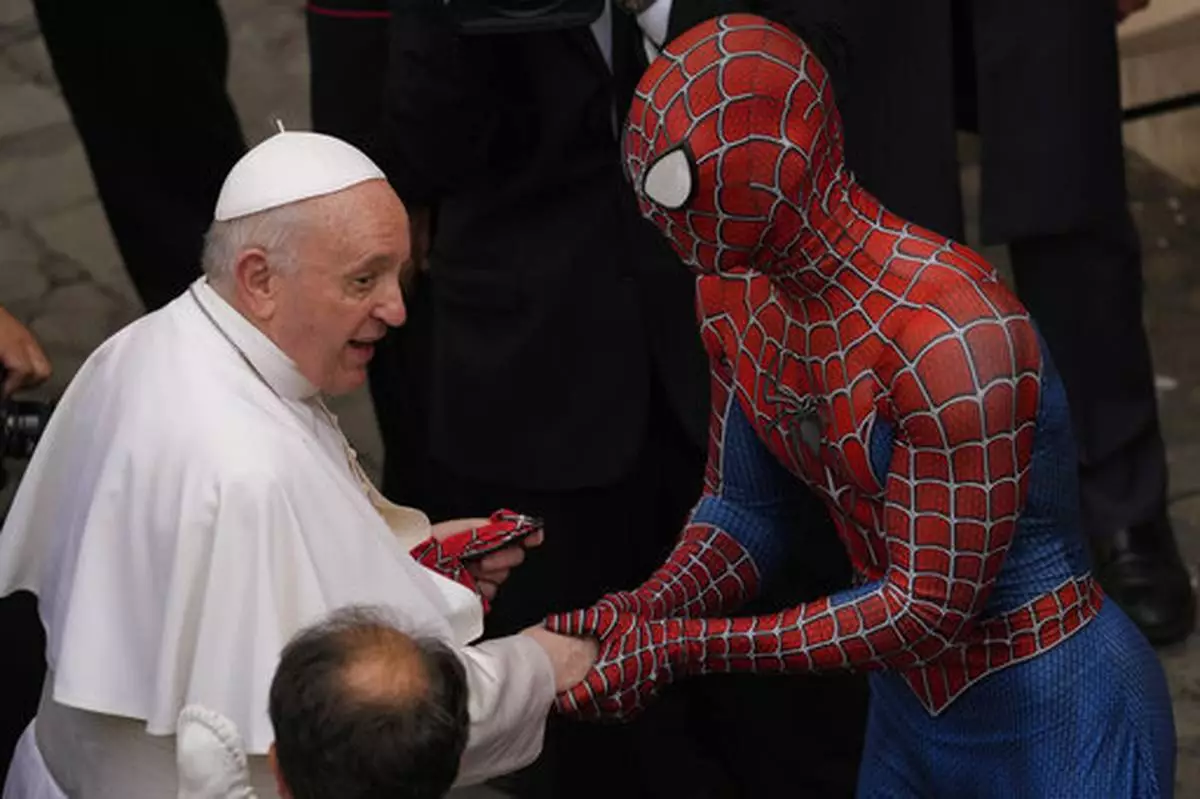 FILE - Pope Francis meets a man wearing a Spider-Man costume, who presented him with his mask, at the end of his weekly general audience with a limited number of faithful in the San Damaso Courtyard at the Vatican, Wednesday, June 23, 2021. (AP Photo/Andrew Medichini, file)