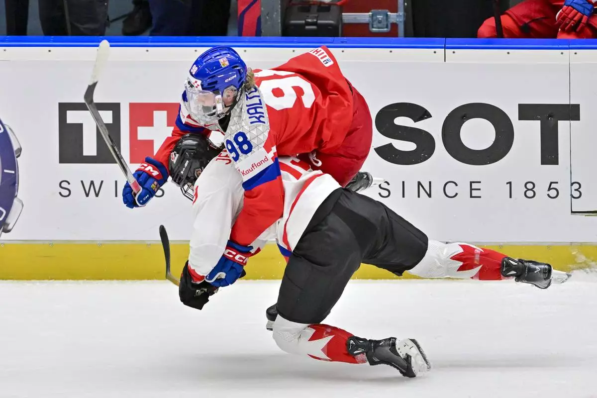 Czech Republic's Kristyna Kaltounkova, top, and Canada's Brianne Jenner in action during the IIHF Women's World Championship, Group A, match between Czech Republic and Canada, in Ceske Budejovice, Czech Republic, Monday, April 14, 2025. (Vaclav Pancer/CTK via AP)