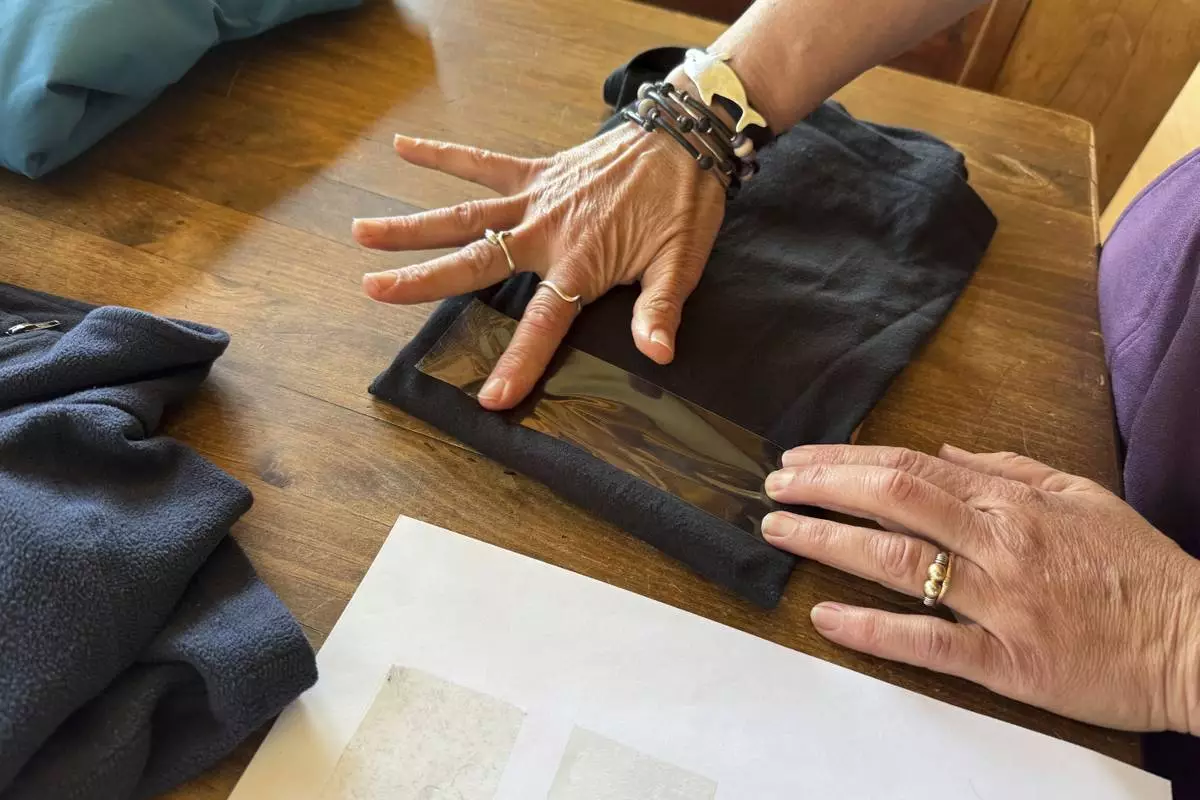 Rachael Z. Miller, founder of the Vermont-based Rozalia Project for a Clean Ocean, conducts a tape test on various clothing items to compare how much each material sheds microfibers on Thursday, April 17, 2025, in Granville, Vt. (AP Photo/Amanda Swinhart)