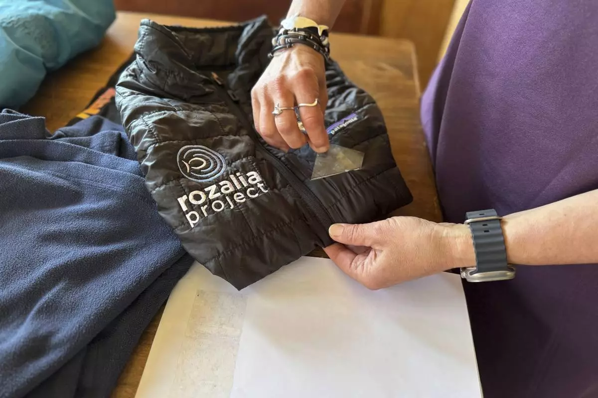Rachael Z. Miller, founder of the Vermont-based Rozalia Project for a Clean Ocean, conducts a tape test on various clothing items to compare how much each material sheds microfibers on Thursday, April 17, 2025, in Granville, Vt. (AP Photo/Amanda Swinhart)