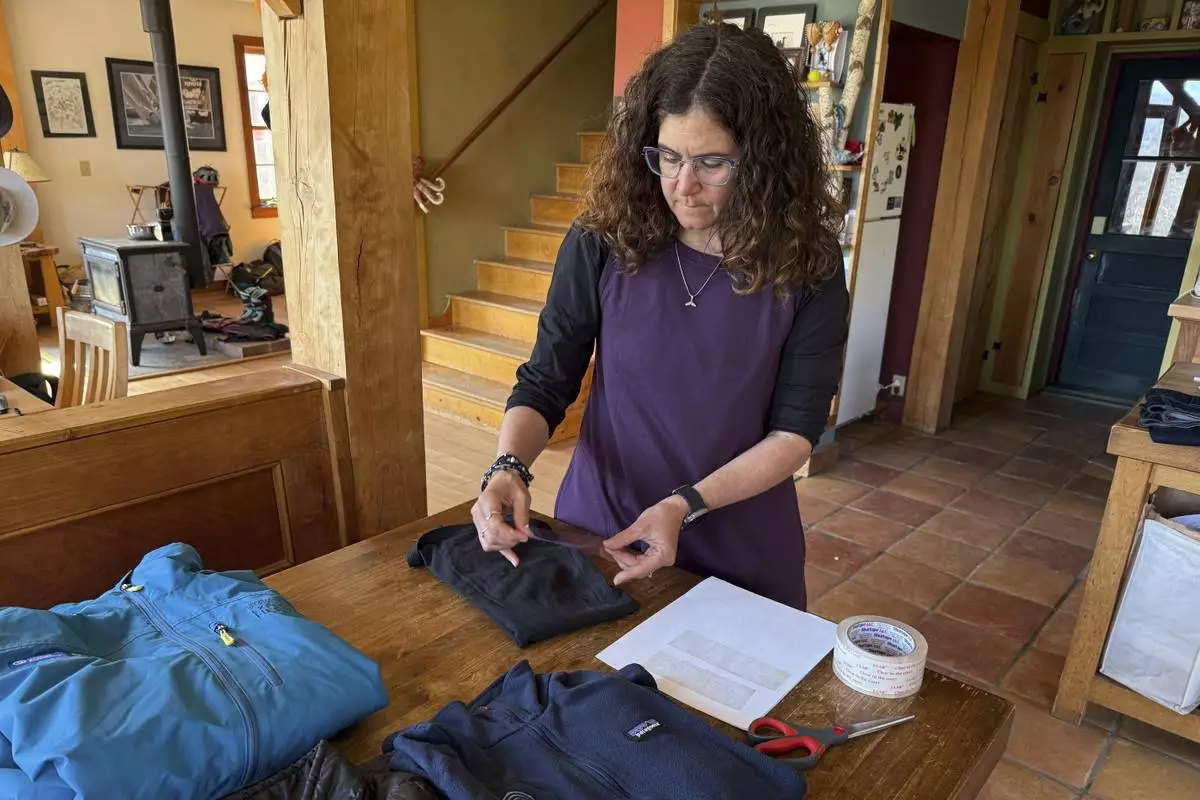 Rachael Z. Miller, founder of the Vermont-based Rozalia Project for a Clean Ocean, conducts a tape test on various clothing items to compare how much each material sheds microfibers on Thursday, April 17, 2025, in Granville, Vt. (AP Photo/Amanda Swinhart)