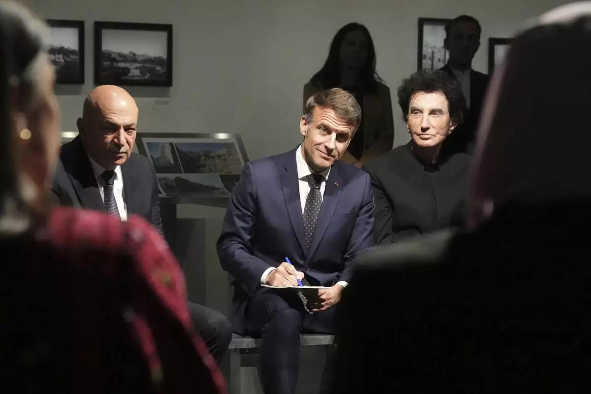 French President Emmanuel Macron, center, Hani al-Hayek, left, the Palestinian Authority's minister for heritage and tourism and IM director Jack Lang listen as they visit the exhibition "Treasures rescued from Gaza" Monday, April 14, 2025 at the Arab World Institute (IMA) in Paris. (AP Photo/Michel Euler, Pool)