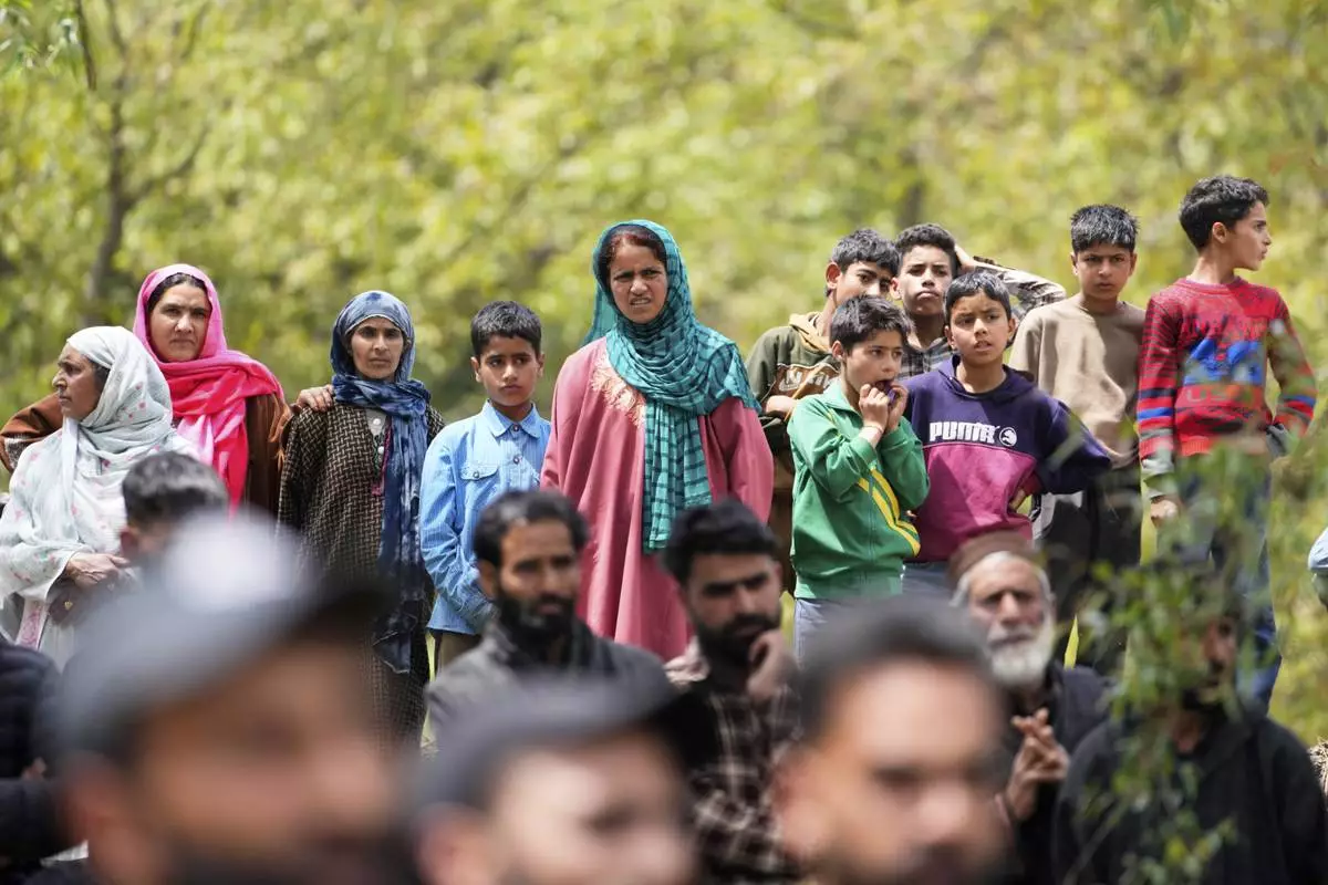 Women and children watch the funeral procession of Adil Hussain Shah, a daily-wage worker, who died when militants indiscriminately opened fire on a crowd of mainly tourists on Tuesday, at his village Hapatnar, about 20 km (13 miles) from Pahalgam where the incident took place, Indian controlled Kashmir, Wednesday, April 23, 2025. (AP Photo/Dar Yasin)