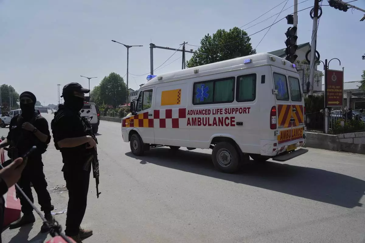 Police guard as ambulances carry bodies of tourists, in Srinagar, Indian controlled Kashmir, Wednesday, April. 23, 2025. (AP Photo/Mukhtar Khan)