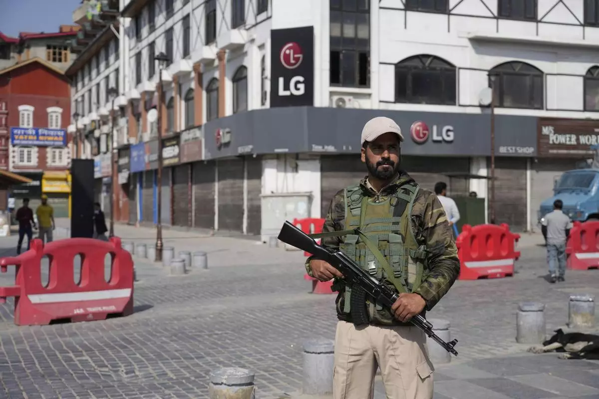 An Indian policeman guards in the city centre during a shut down after tourists were killed, in Srinagar, Indian controlled Kashmir, Wednesday, April. 23, 2025. (AP Photo/Mukhtar Khan)