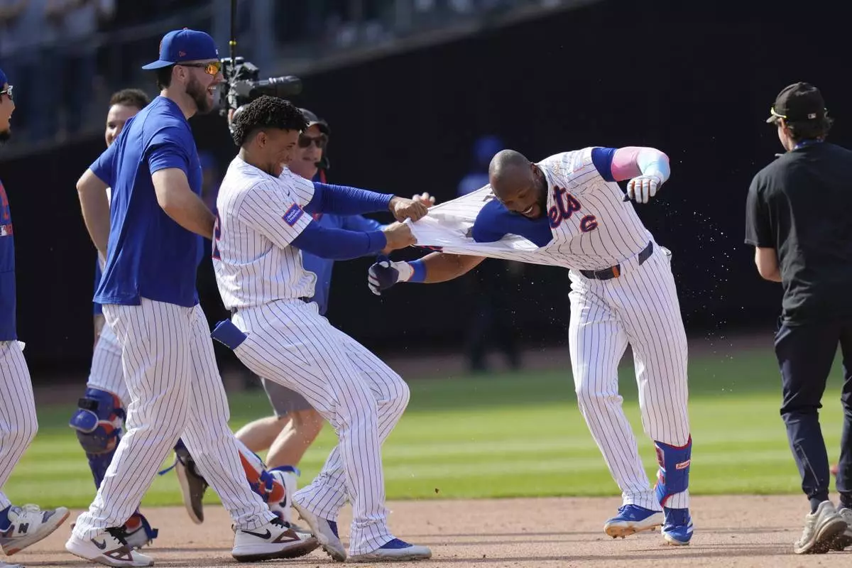New York Mets' Starling Marte, right, celebrates with teammates after hitting a walk-off single during the tenth inning of a baseball game against the Philadelphia Phillies, Wednesday, April 23, 2025, in New York. (AP Photo/Seth Wenig)