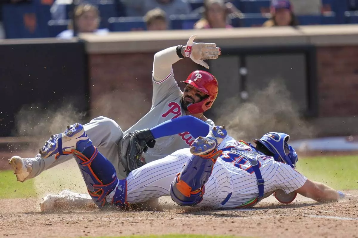 New York Mets catcher Hayden Senger, right, tags out Philadelphia Phillies' Nick Castellanos as he tries to score during the eighth inning of a baseball game, Wednesday, April 23, 2025, in New York. (AP Photo/Seth Wenig)
