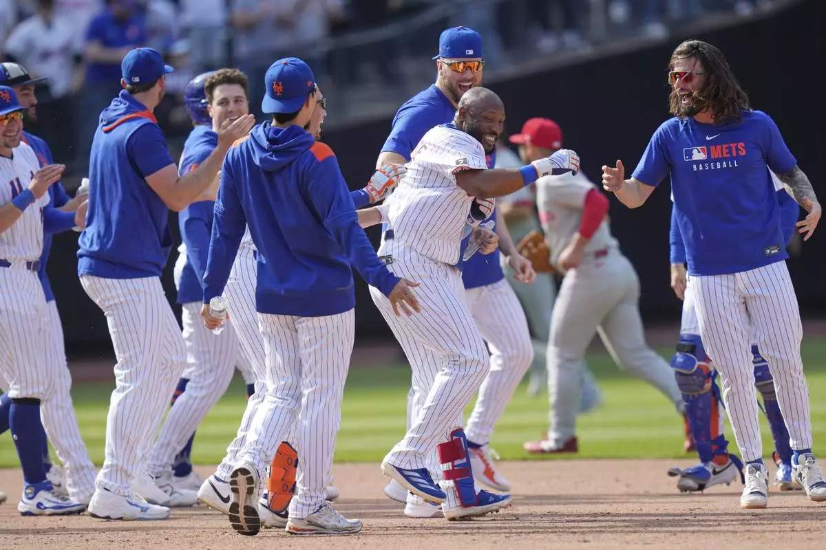 New York Mets' Starling Marte, center, celebrates with teammates after hitting a walk-off single during the tenth inning of a baseball game against the Philadelphia Phillies, Wednesday, April 23, 2025, in New York. (AP Photo/Seth Wenig)